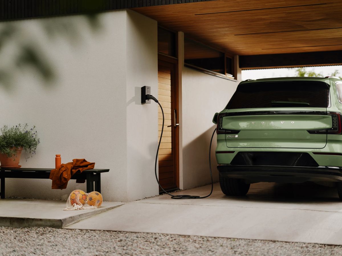Een elektrische auto aan de laadpaal onder een carport